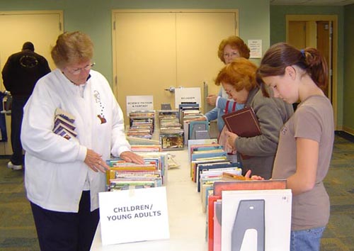 Library patrons browsing the selection at a book sale